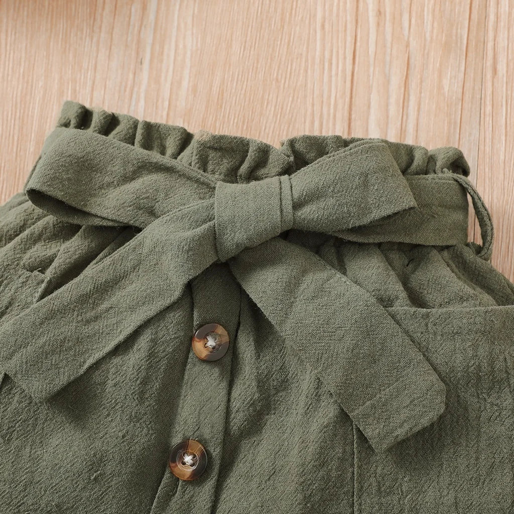 Close-up of olive green fabric with buttons and a bow detail from 2PCS Baby Girl Clothing Set by Yamza Tots' Closet