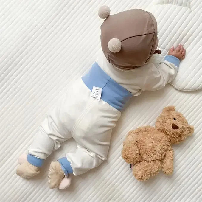 Baby wearing Baby 2PCS Pajama Set Cotton Long Sleeve Outfit for Autumn Winter Wear lying on white textured surface next to teddy bear