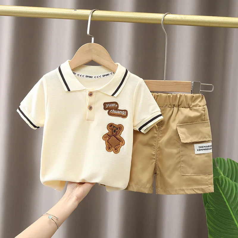 Baby boy clothes set with cream polo shirt featuring bear patch and khaki shorts with pocket