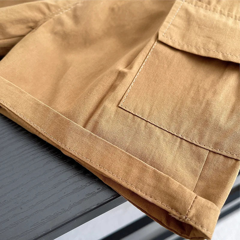Close up of tan fabric with pocket detail on baby boys striped clothing suits by Yamza Tots' Closet