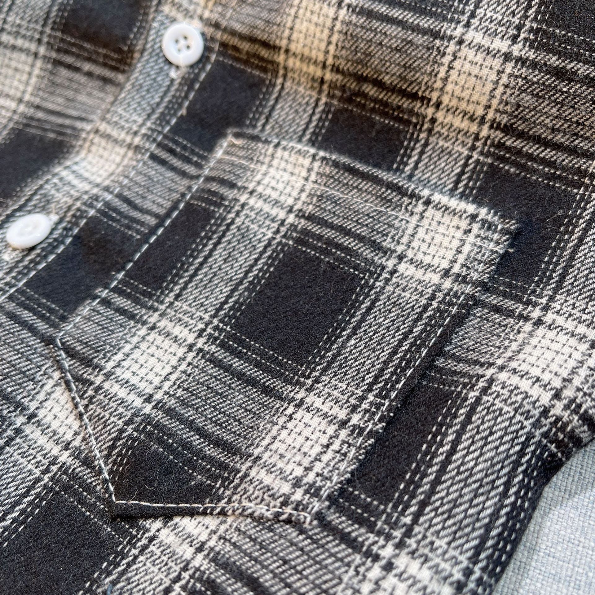 Close-up of black and white plaid fabric with white buttons and pocket detail from Baby Boys Summer Plaid Outfit Cozy Striped Shirts Tees and Shorts Set