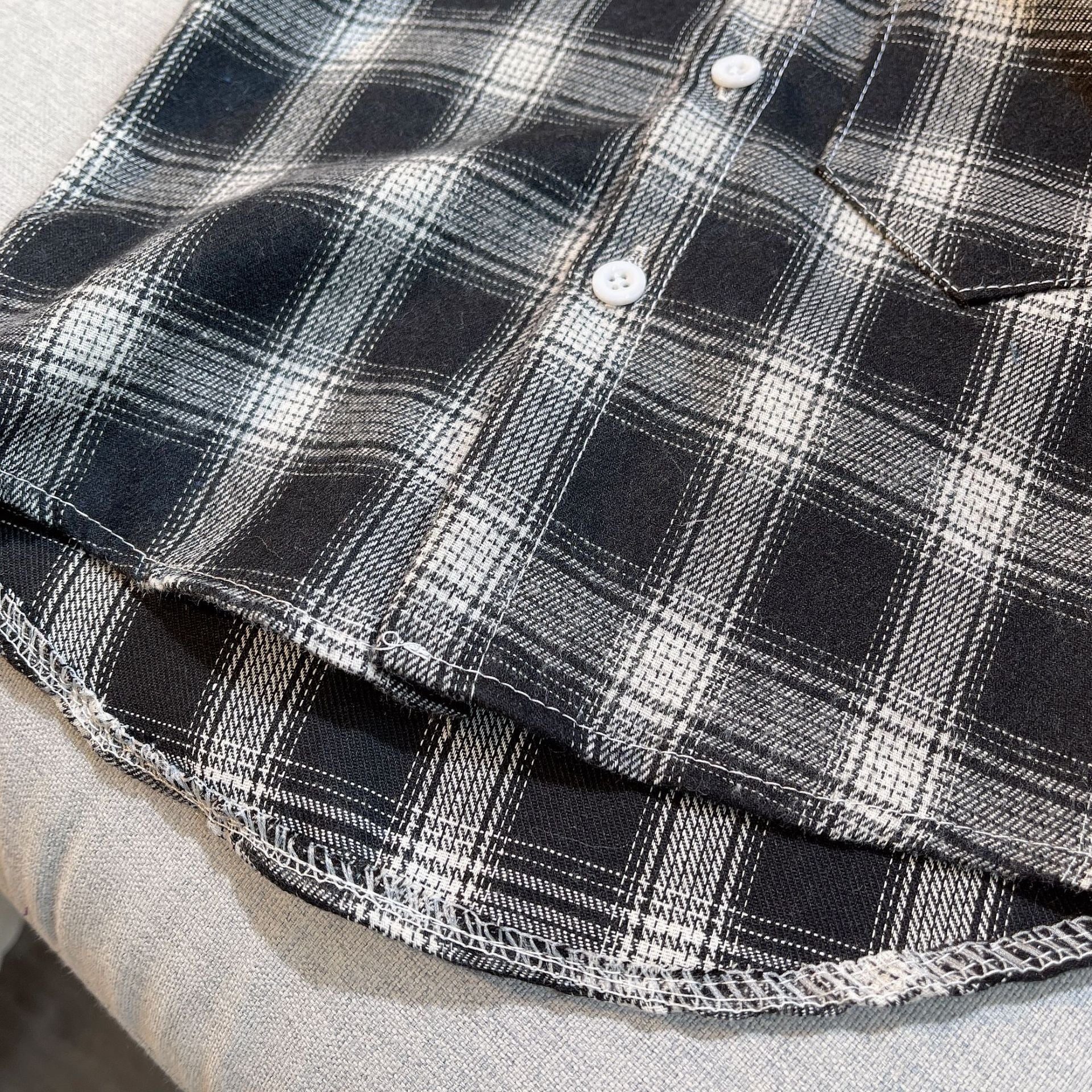 Close-up of black and white plaid fabric with buttons from Baby Boys Summer Plaid Outfit Cozy Striped Shirts Tees and Shorts Set