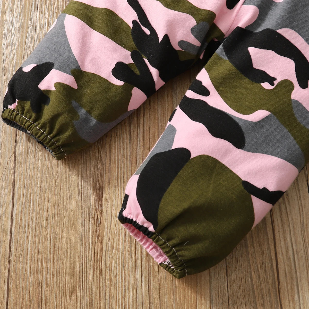 Close-up of Baby Girl Camouflage Outfit Set with Long Sleeve Bodysuit and Headband pink green and gray camo fabric