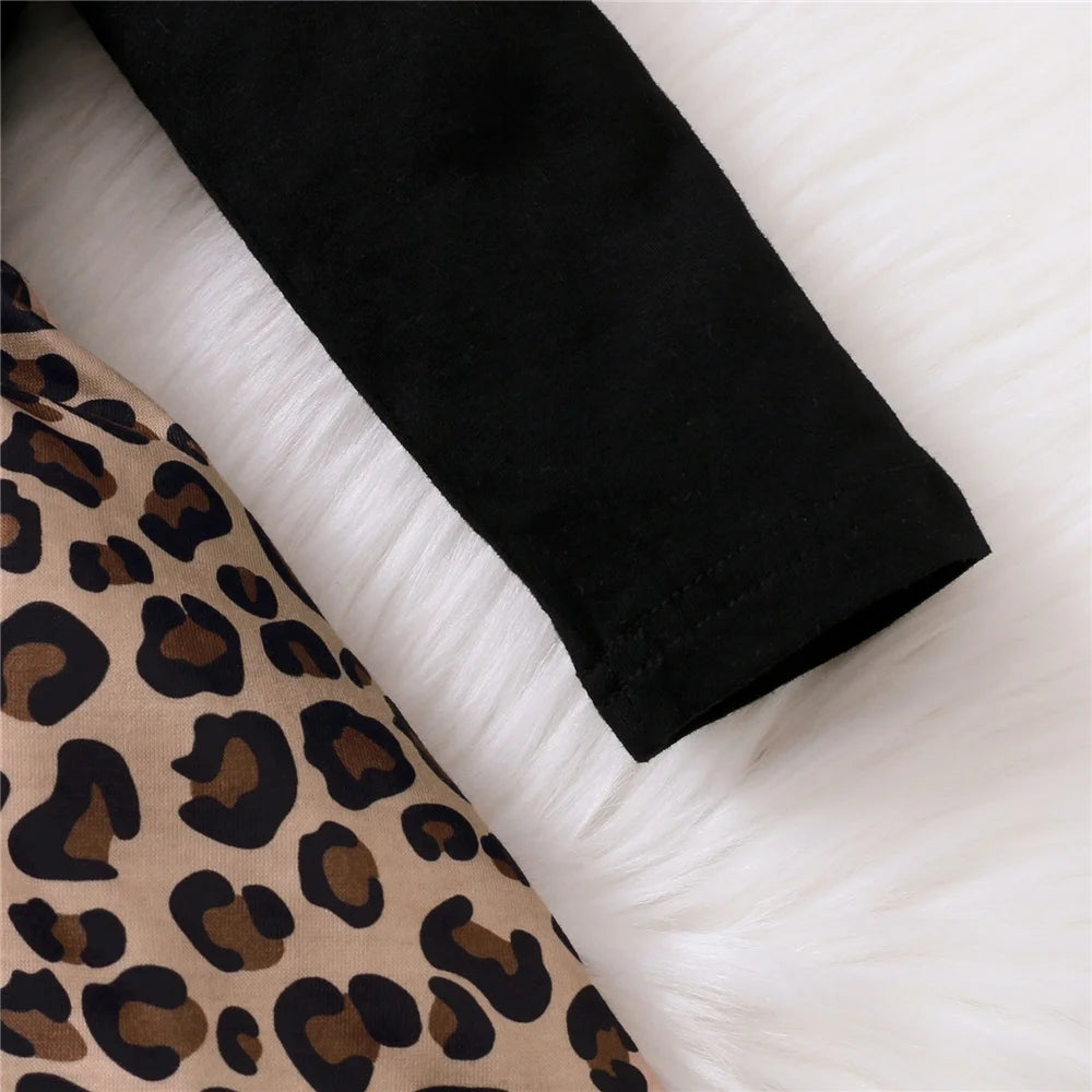 Close-up of leopard print and black fabric detail on baby girl dress with bow by Yamza Tots Closet
