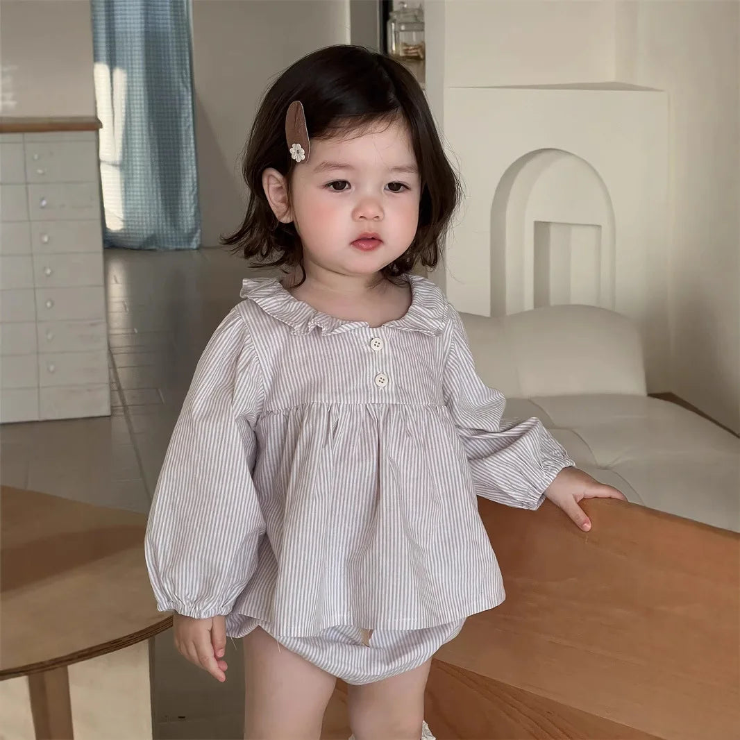 Baby girl wearing a Baby Girl Loose Striped Set with long sleeves and ruffle collar indoors