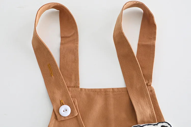 Close-up of brown overall straps from Yamza Tots' Closet baby girls and boys clothing