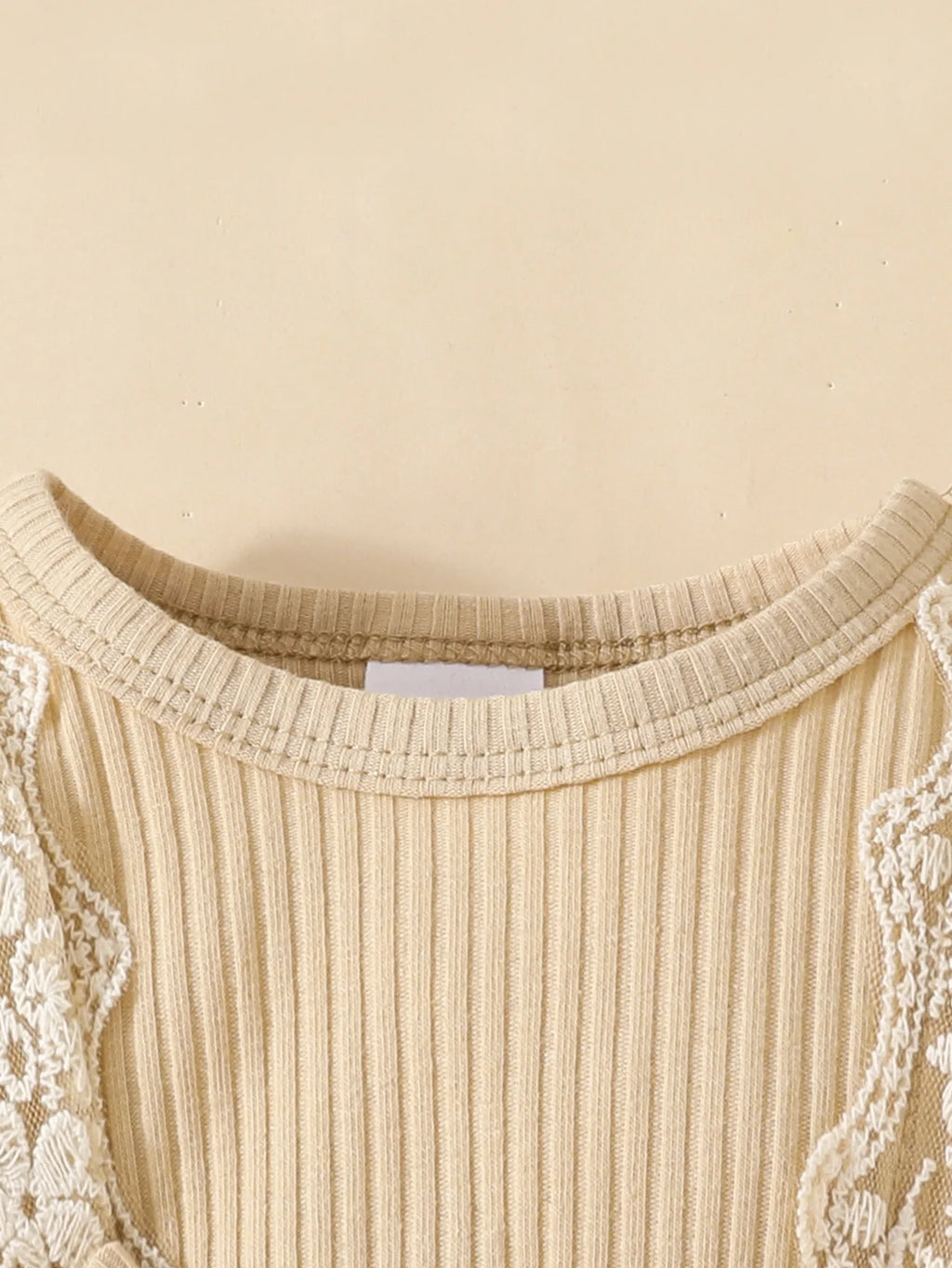 Close-up of beige ribbed knit baby girls long sleeve plaid with bow blouse featuring delicate lace trim