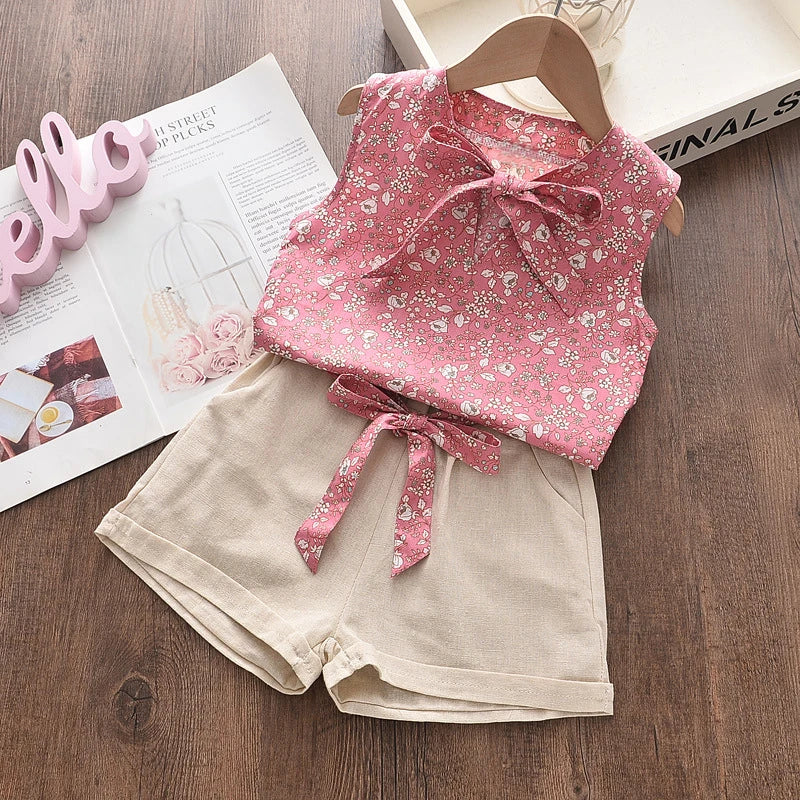 Baby Girls Sleeveless Vest Shorts 2Pcs Sets with pink floral vest and beige shorts on wooden background