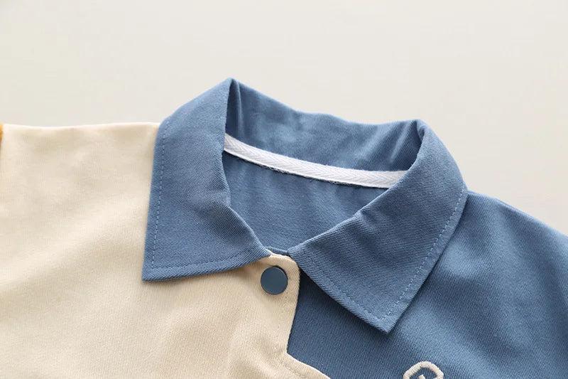 Close-up of boys cartoon excavator jacket t-shirt and pants tracksuit set collar with blue and beige fabric