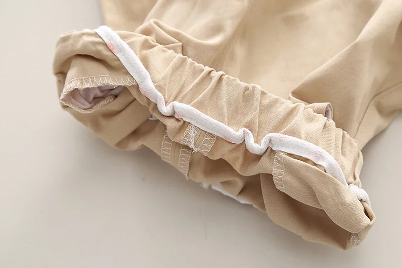 Close-up view of beige boys' casual fashion set long sleeve shirt and cargo pants cuff with white trim detailing