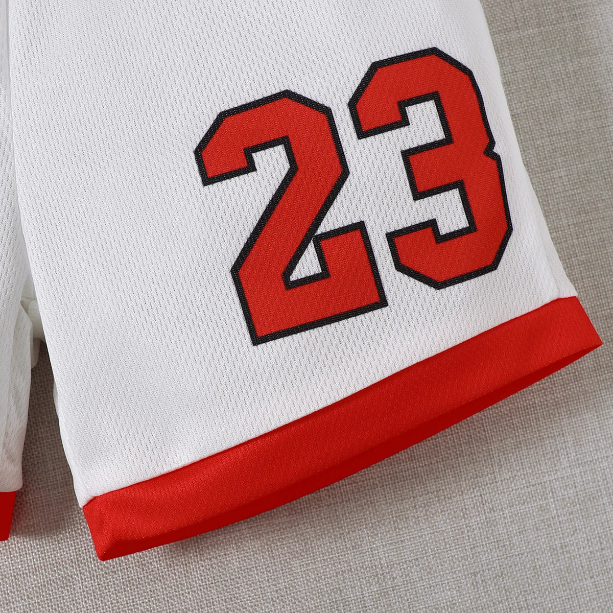 Close-up of Boys Sports Style Set Round Neck Letter 23 Basketball Suit 2 Piece Summer Outfit shorts with red trim