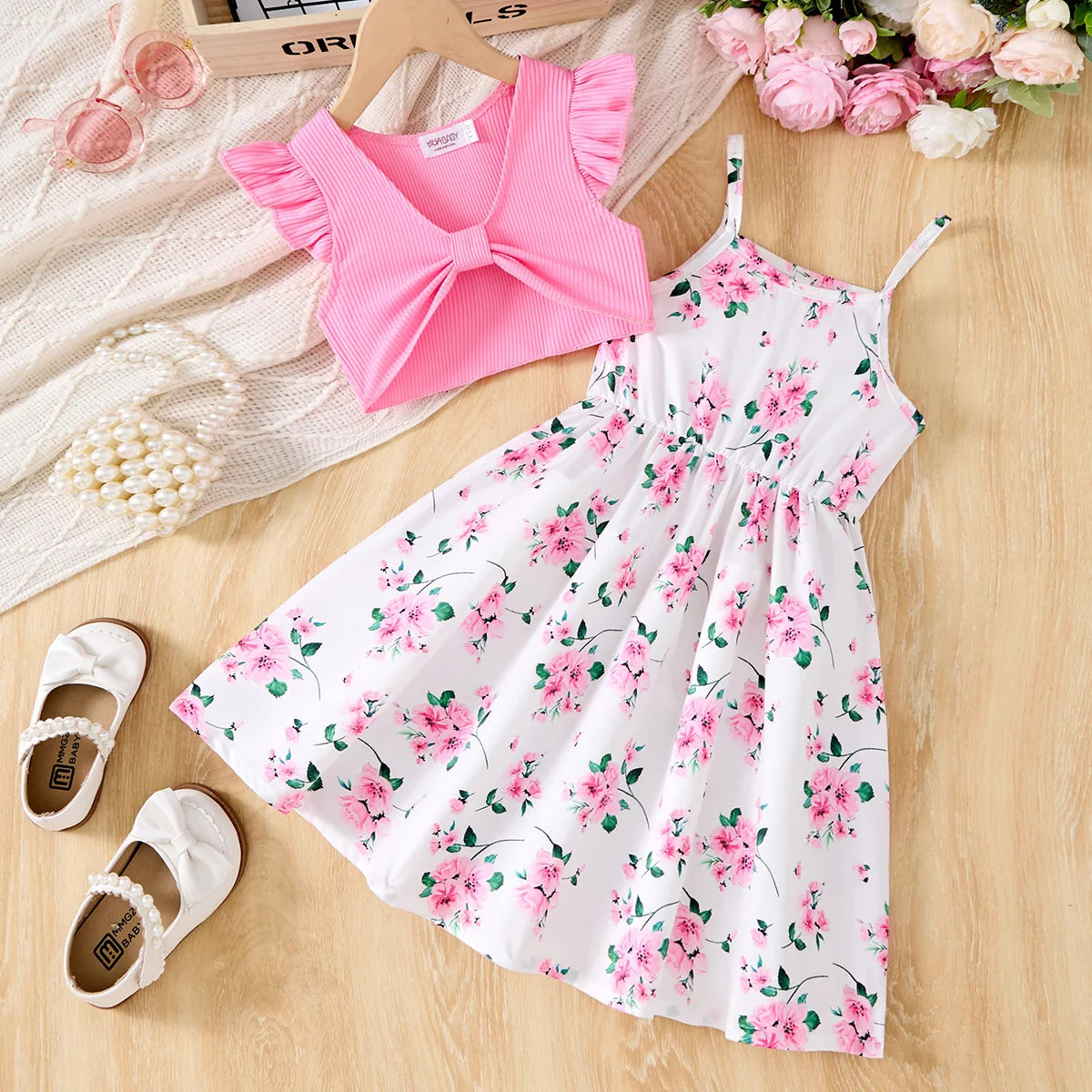 Children Casual Dress Girls Pink Knitted Top Floral Suspender Dress Summer Set laid out with white shoes and flowers