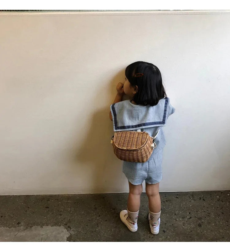 Child wearing Children Clothing Sets Boys Girls Muslin Top Shorts 2pcs Cotton Baby Outfit with a wicker backpack