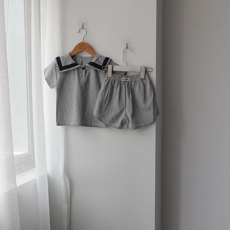 Children Clothing Sets Boys Girls Muslin Top Shorts 2pcs Cotton Baby Outfit in gray with navy collar hanging on wall
