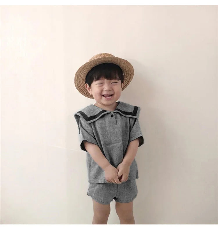 Children Clothing Sets Boys Girls Muslin Top Shorts 2pcs Cotton Baby Outfit gray with black trim worn by smiling toddler in straw hat