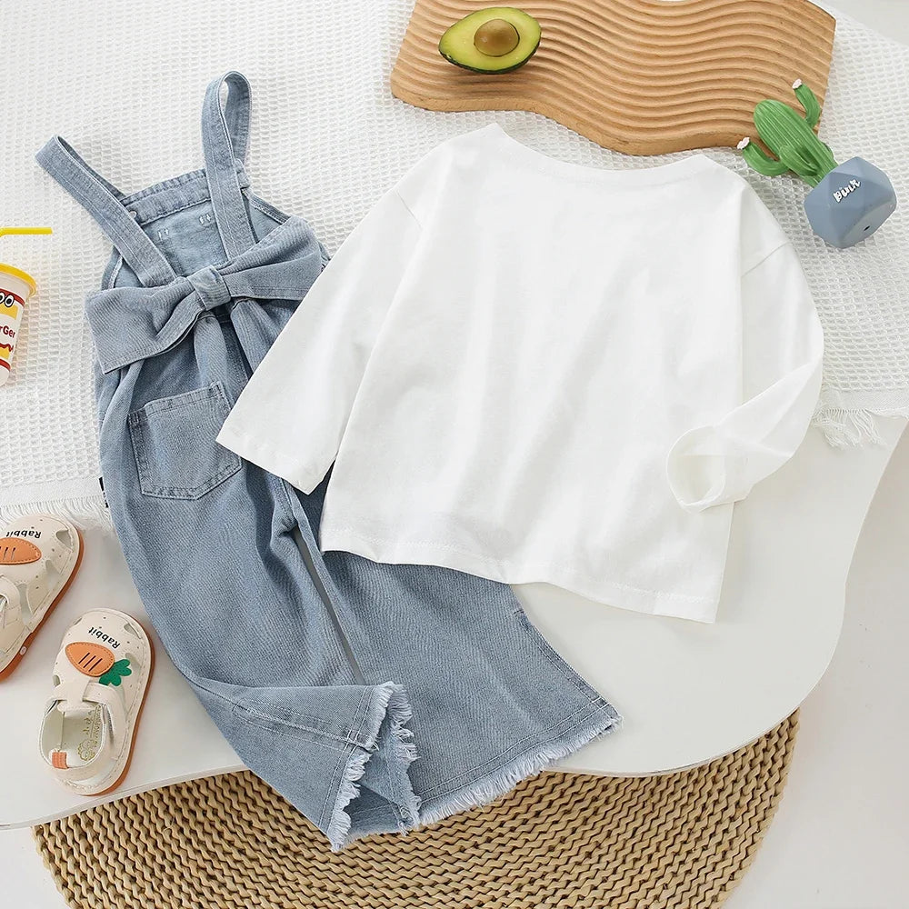 Children Clothing Sets Long Sleeve T Shirt Bow Suspenders Jeans Girls Baby Outfit laid out with white long sleeve shirt and denim suspenders jeans