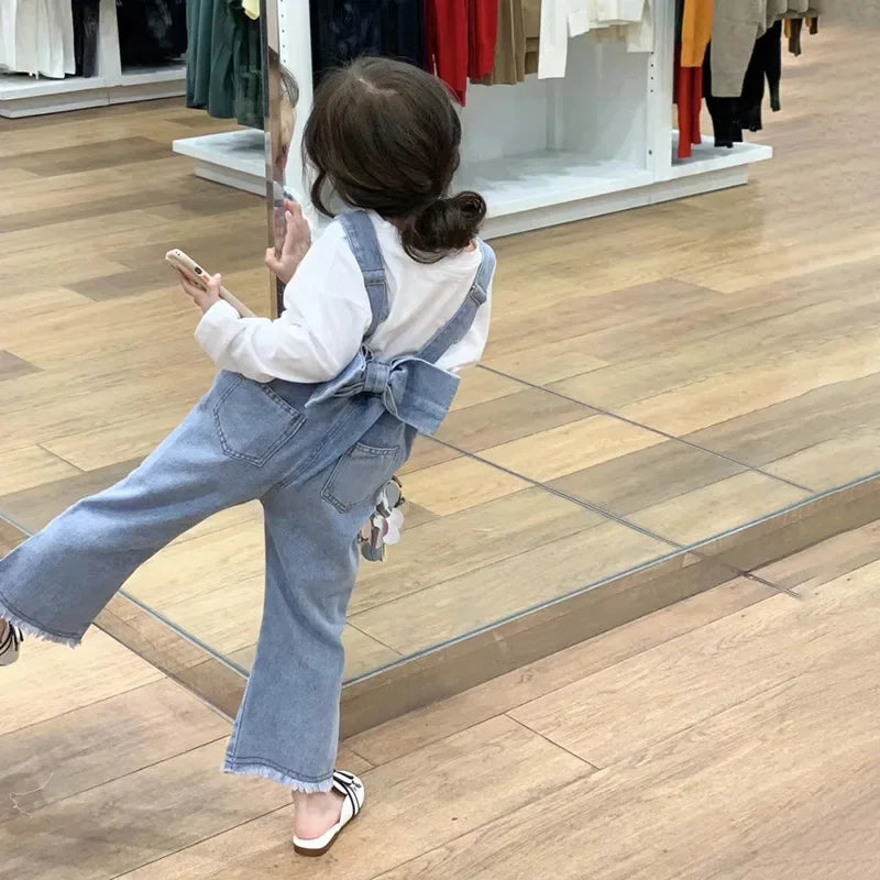 Children Clothing Sets Long Sleeve T Shirt Bow Suspenders Jeans Girls Baby Outfit worn by child in store with wood floor