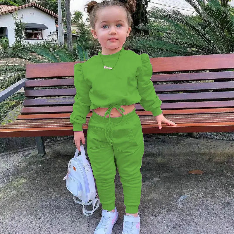 Children girls clothes set autumn long sleeve crop tops and casual pants outfit in green worn by toddler with white sneakers and backpack