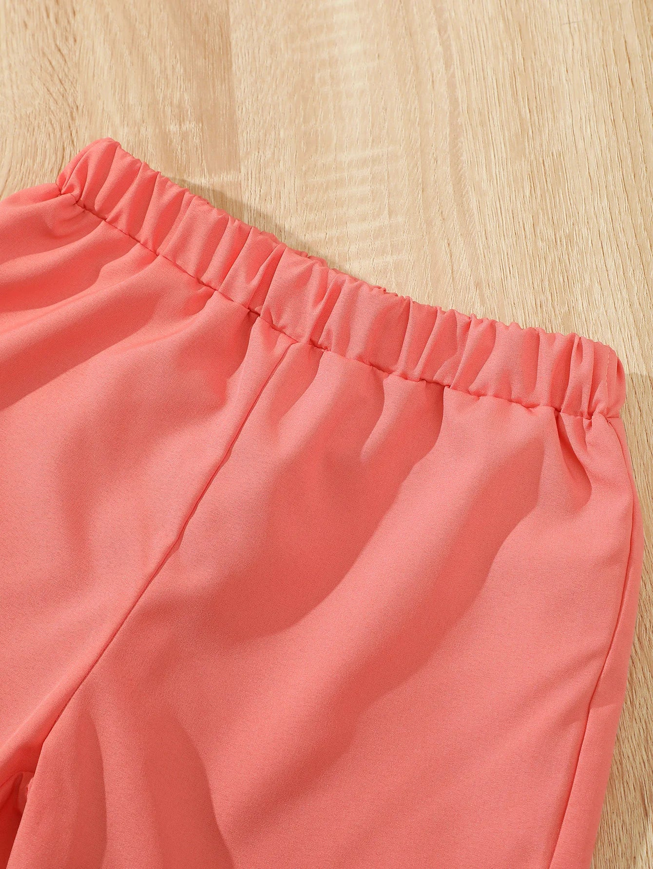 Close-up of coral pink elastic waistband shorts from Children Girls Summer Set Round Neck Floral Bow Sleeveless Top and Shorts 2Pc