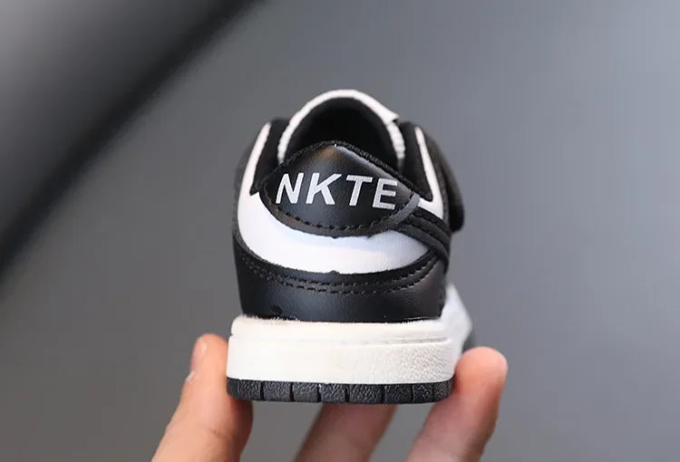 Children White Casual Sneakers Soft-Soled Running Shoes for Boys and Girls black and white rear view held in hand