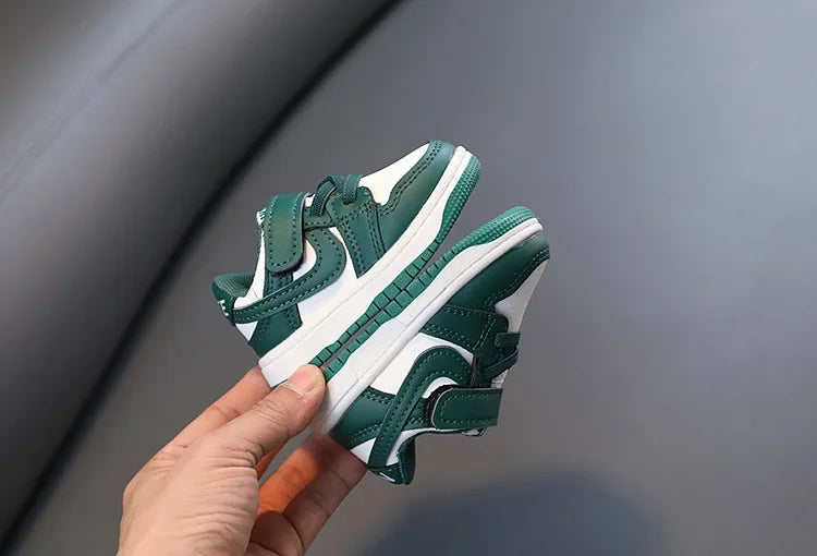 Children White Casual Sneakers Soft-Soled Running Shoes for Boys and Girls in green and white held in hand