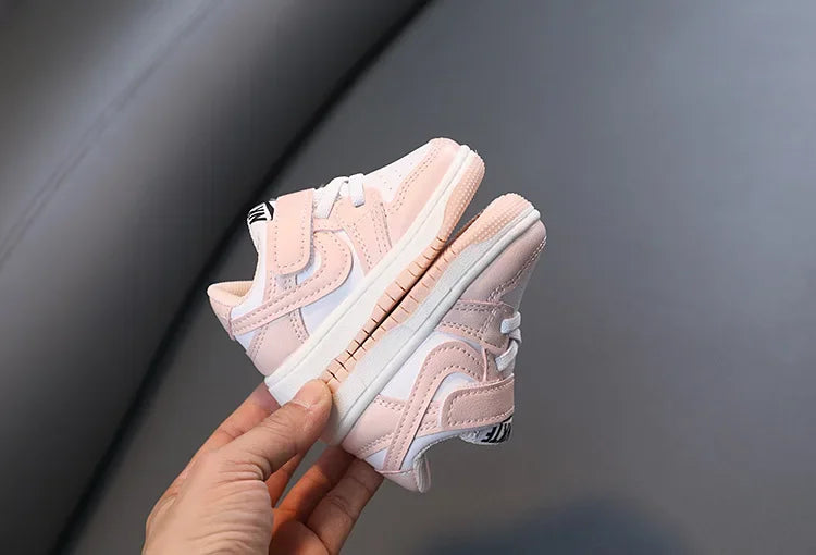 Children White Casual Sneakers Soft-Soled Running Shoes for Boys and Girls in pink and white held in hand