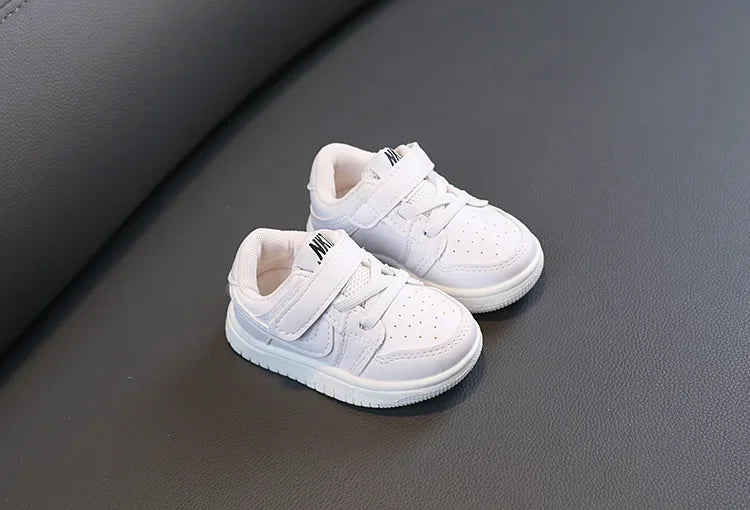 Children White Casual Sneakers Soft-Soled Running Shoes for Boys and Girls placed on dark surface