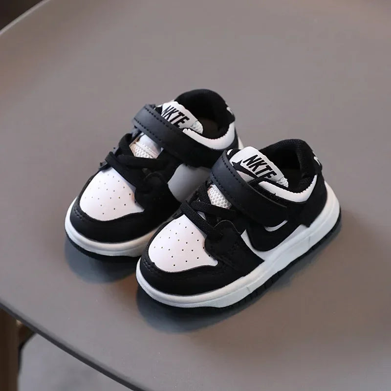 Black and white children's sneakers with velcro straps and breathable mesh upper