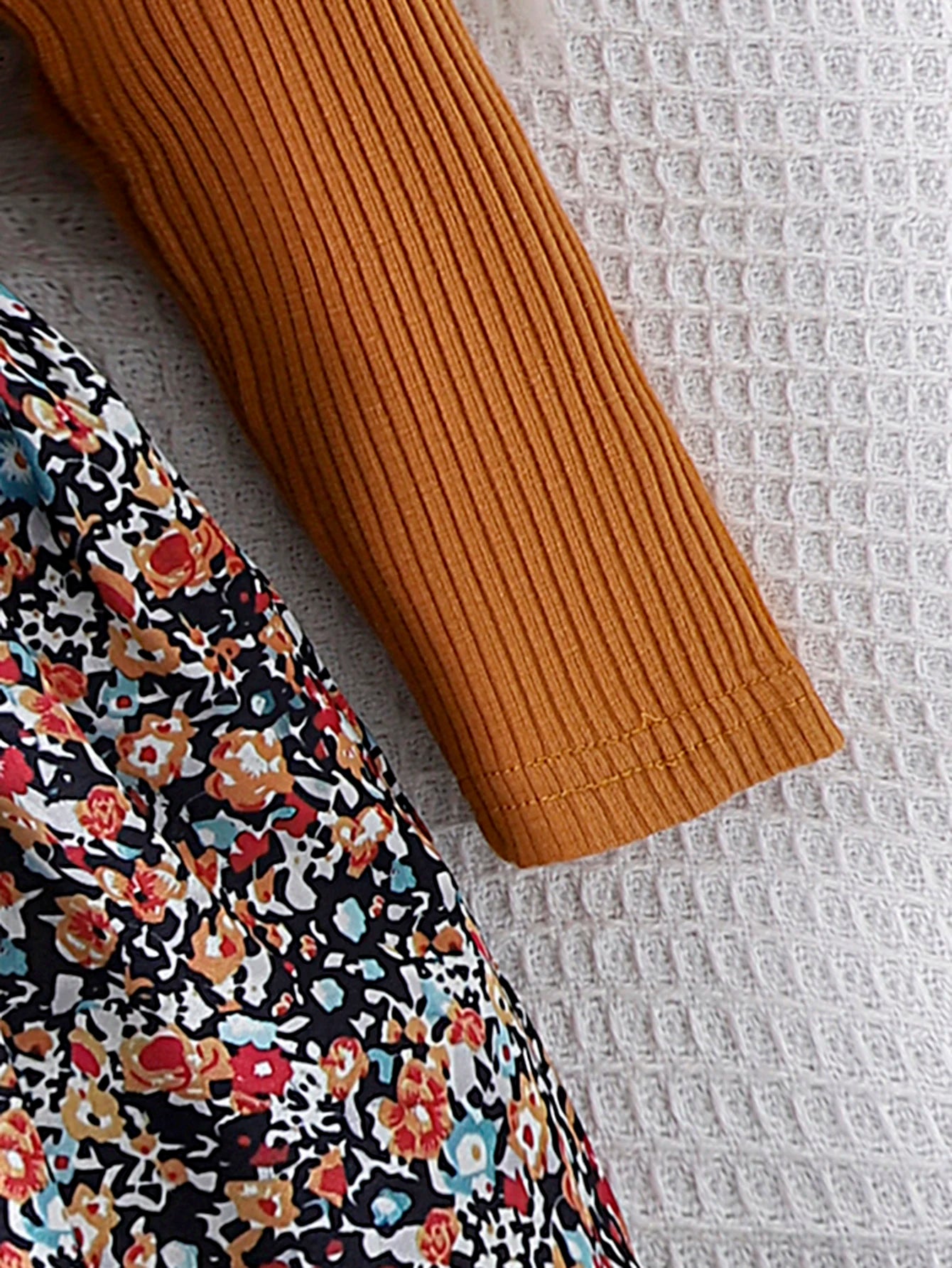 Close-up of a floral patterned fabric with mustard ribbed sleeve, comfortable fashionable kidswear by Yamza Tots' Closet