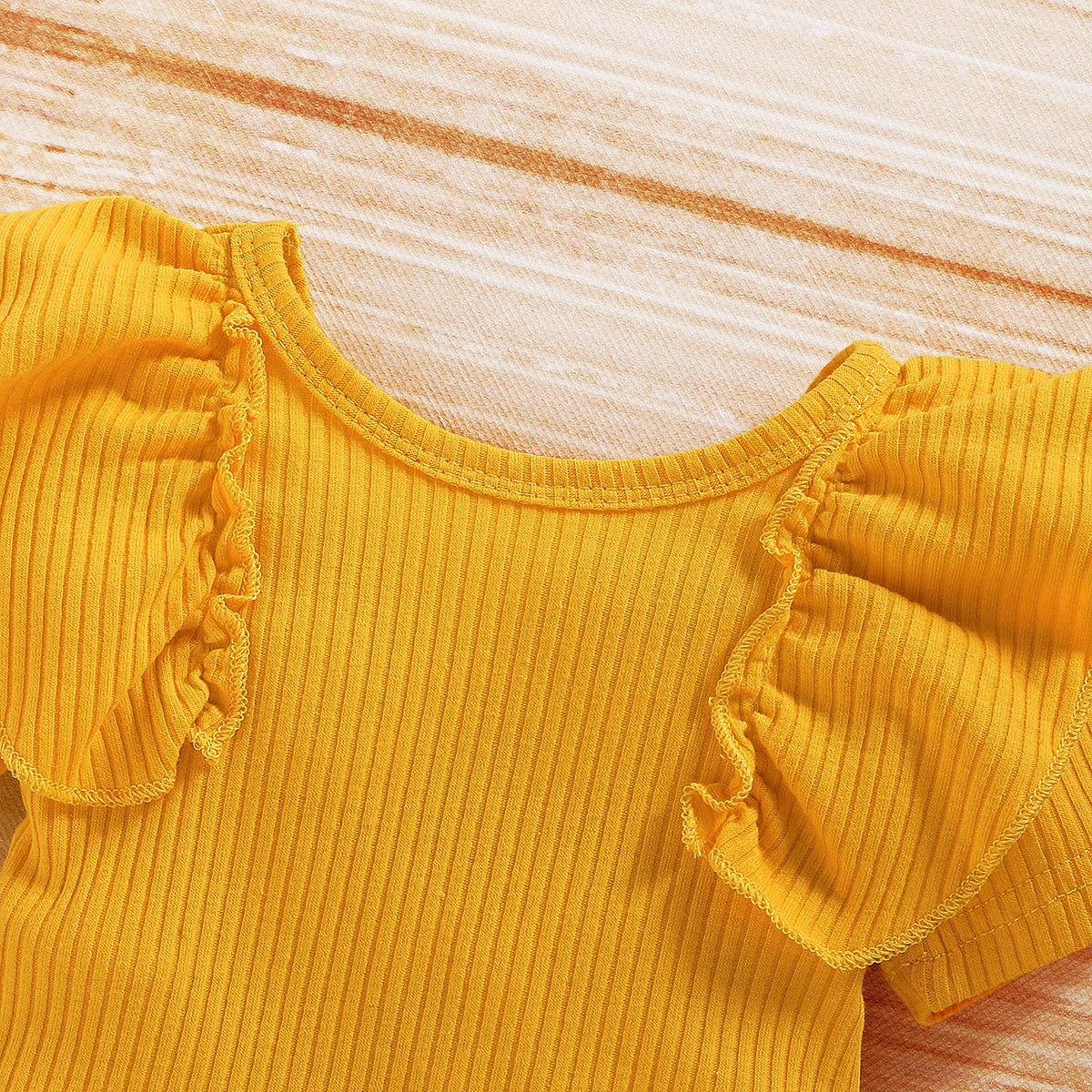 Close-up of Cute Baby Girl Clothing Set Yellow Romper Top with ruffled sleeves from Yamza Tots' Closet