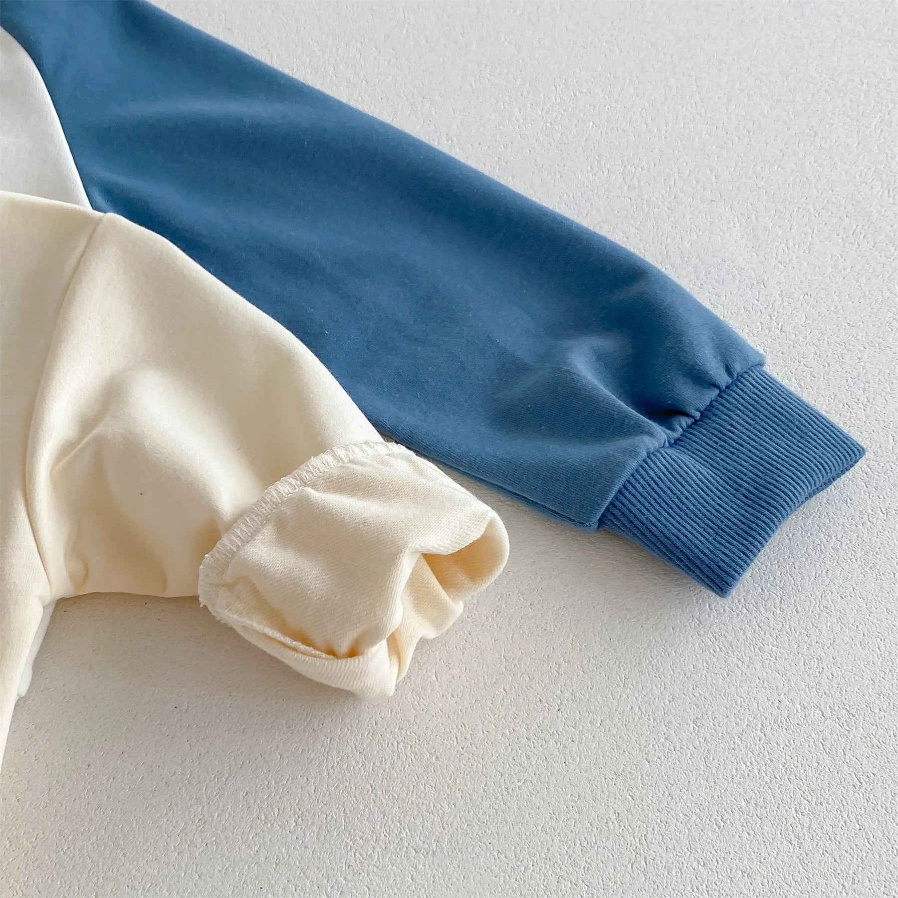 Close-up of blue and cream sleeves on a Disney Cartoon Tracksuit by Yamza Tots' Closet