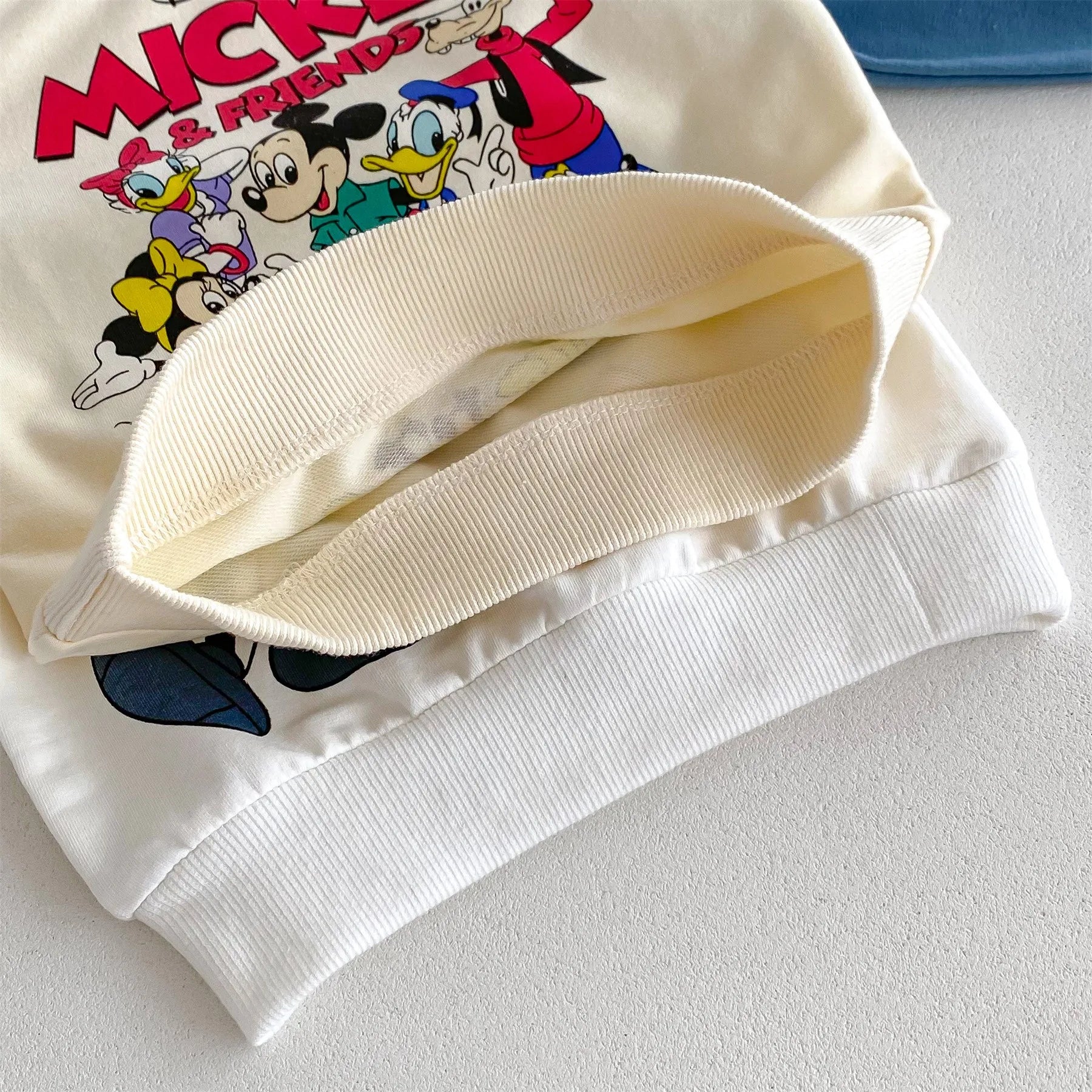 Close-up of white Disney Cartoon Tracksuit sweatshirt featuring Mickey and friends graphic print