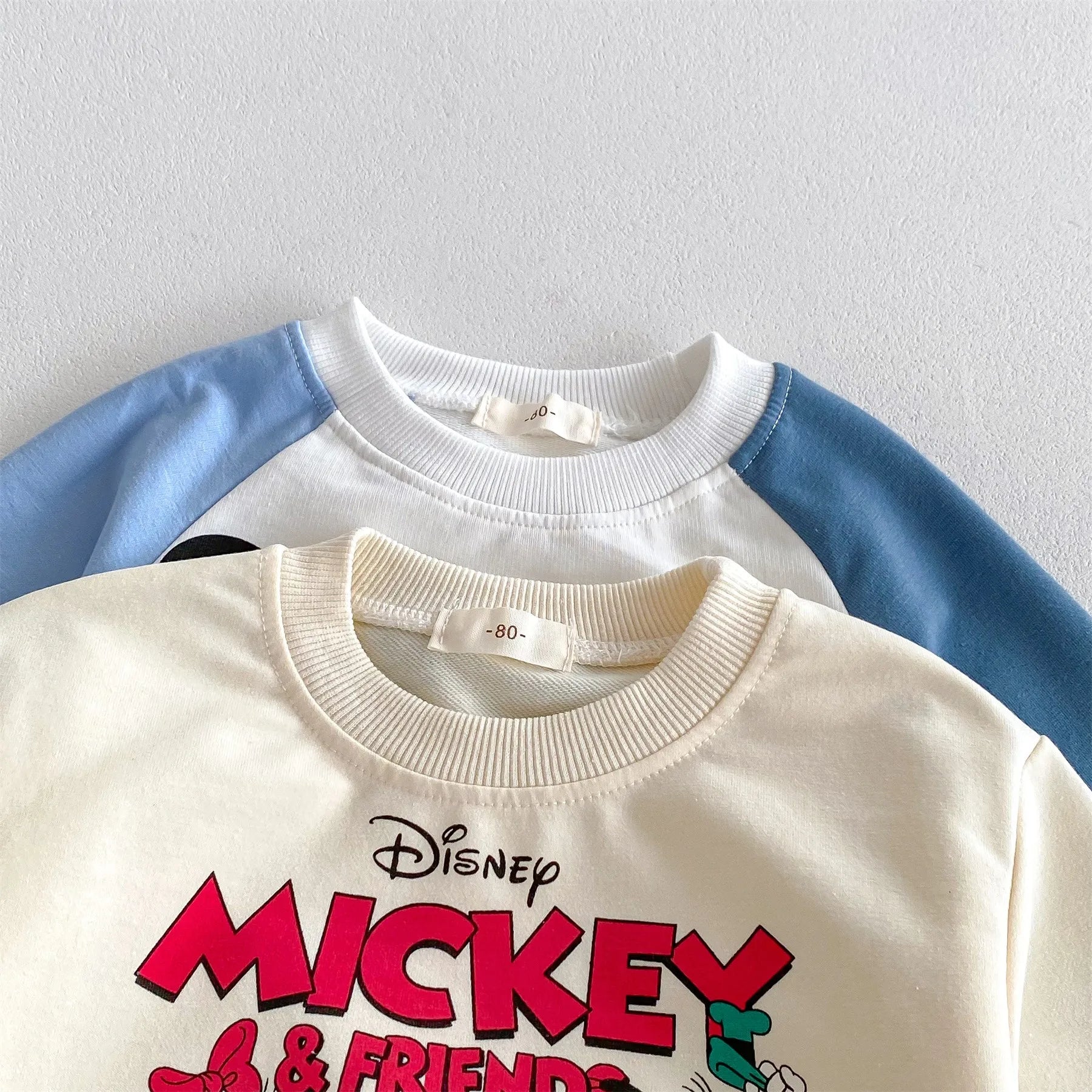 Disney Cartoon Tracksuit featuring Mickey and Friends graphic on cream sweatshirt with blue and white sleeves
