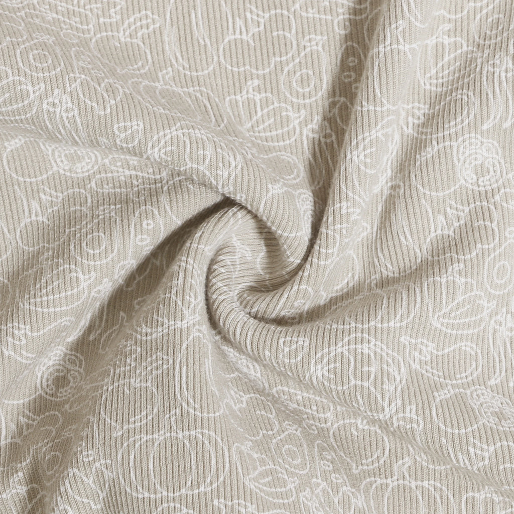 Beige fabric close-up with white abstract patterns showcasing Family Ribbed Print Sets for Summer and Spring by Yamza Tots' Closet