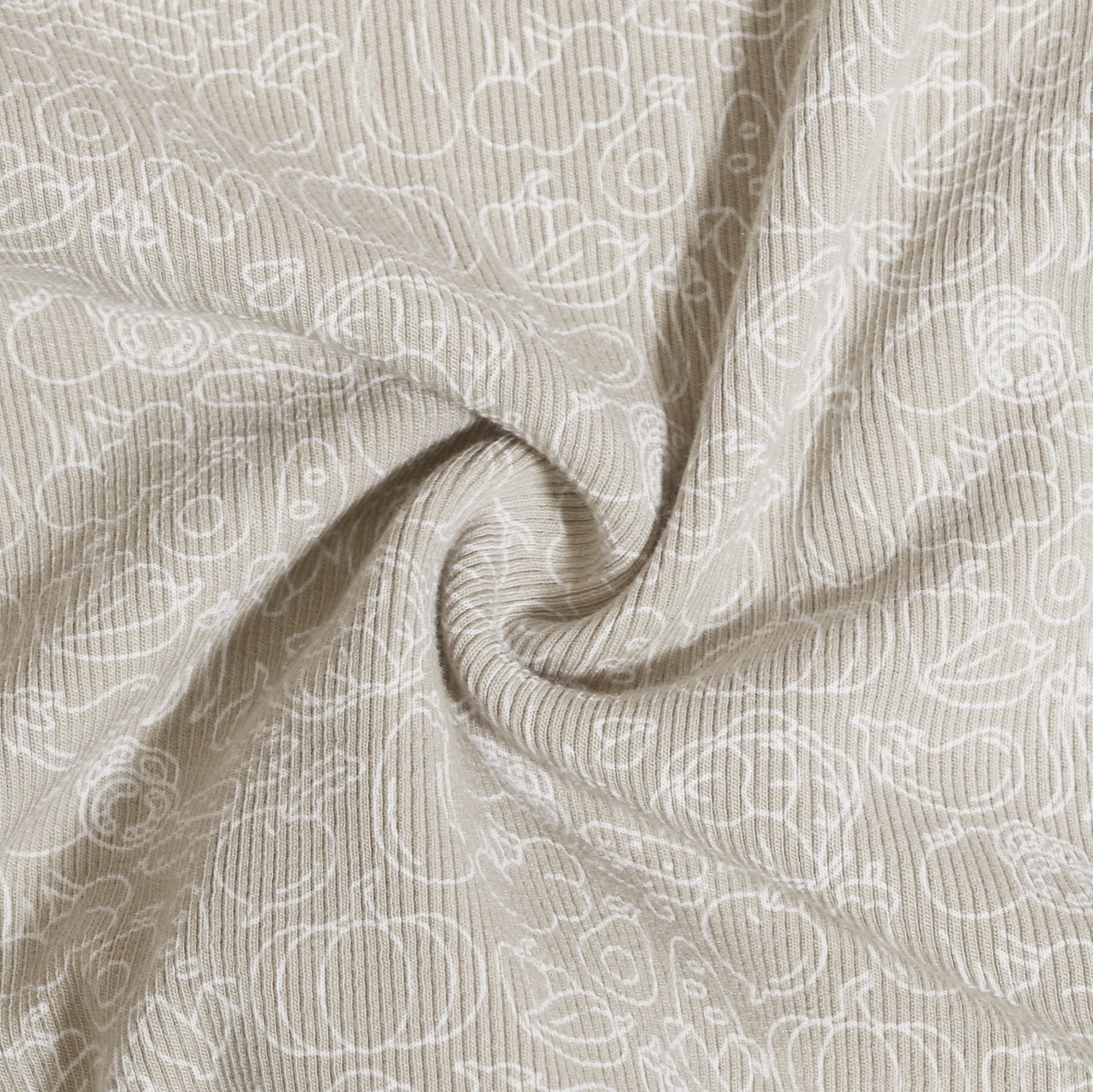 Beige fabric close-up with white abstract patterns showcasing Family Ribbed Print Sets for Summer and Spring by Yamza Tots' Closet