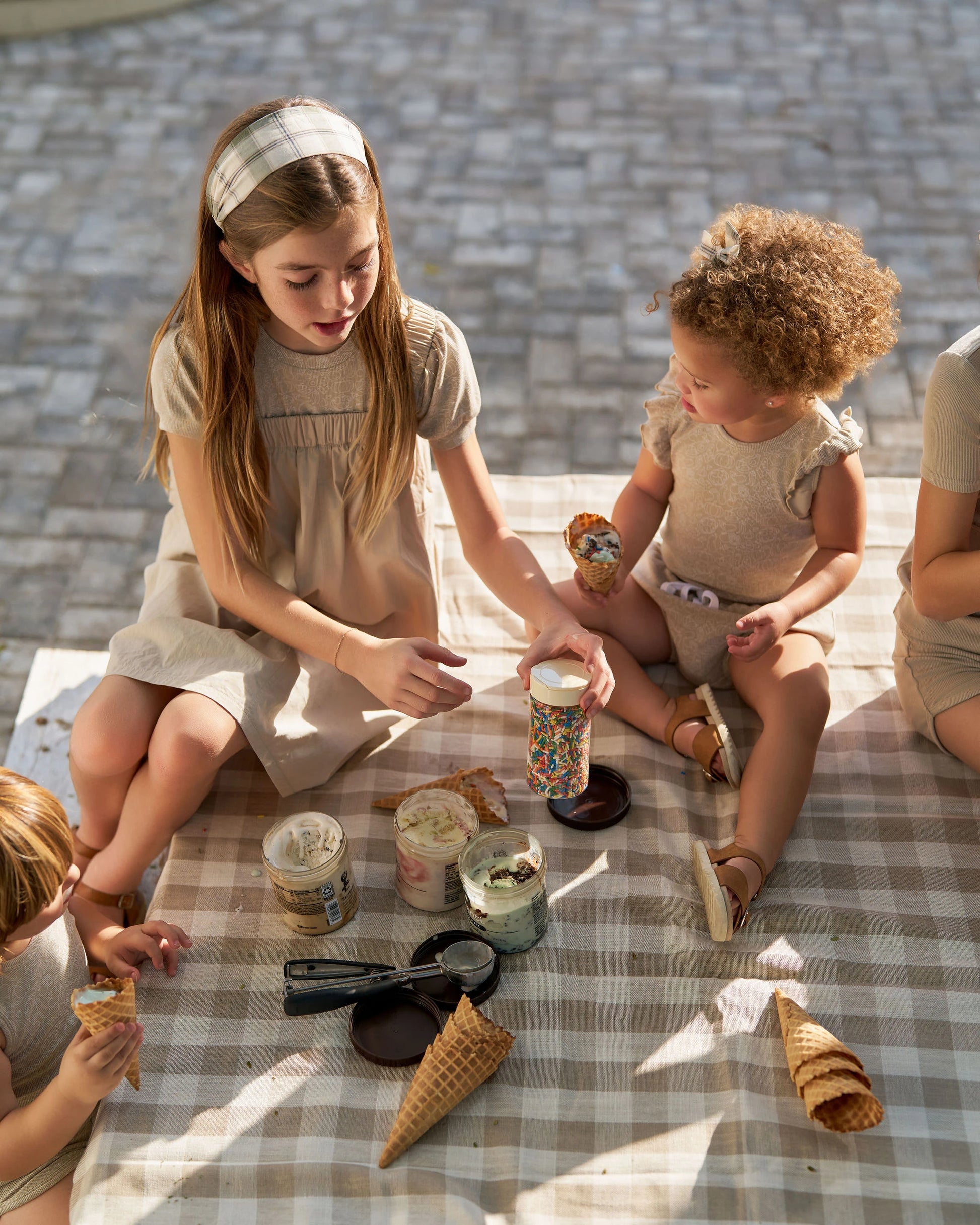Children wearing neutral Family Ribbed Print Sets for Summer and Spring sitting on picnic blanket with ice cream cones