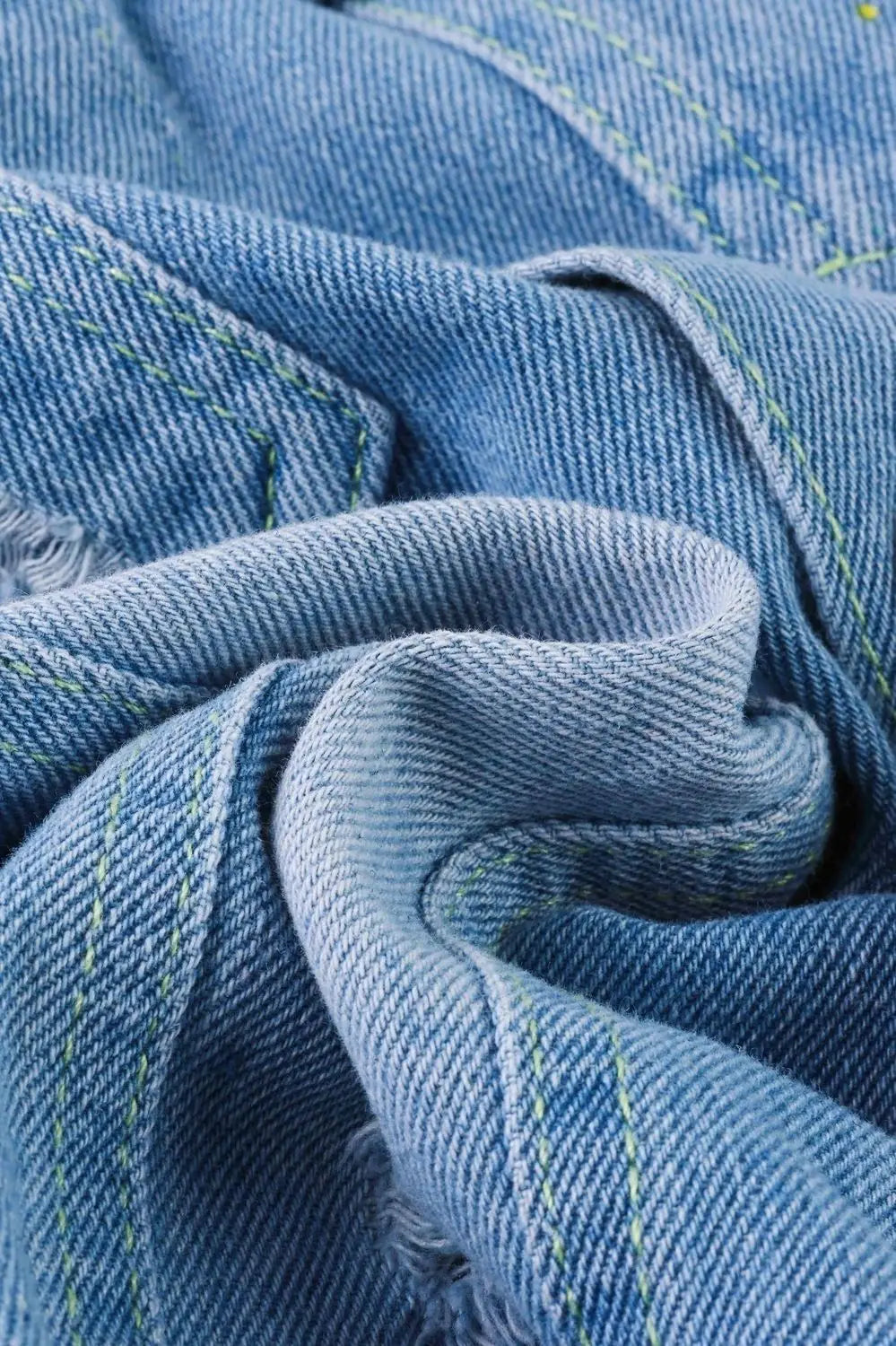 Close-up of blue denim fabric with green stitching from Fashion Baby Girls Hello Kitty Kuromi Denim Jacket Coat Spring Autumn Wear
