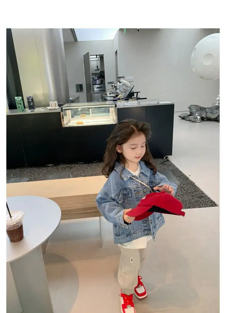 Fashion Kids Denim Jacket Girls Spring Autumn Casual Coat Children Outerwear worn by a girl holding a red hat indoors