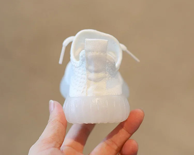 White Fashion Kids Sneakers Breathable Non-slip Casual Running Shoes for Boys Girls held by hand