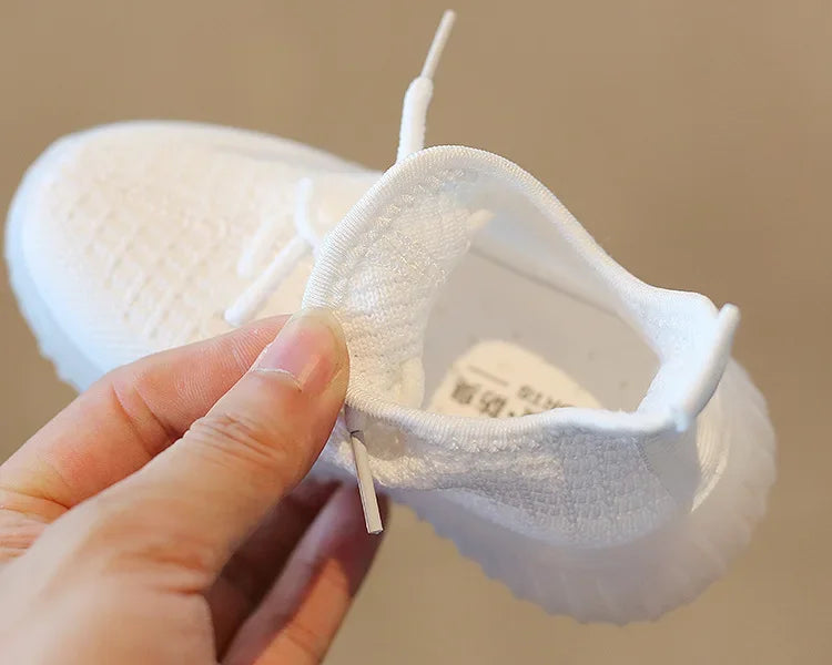 Fashion Kids Sneakers Breathable Non-slip Casual Running Shoes for Boys Girls in white held by hand