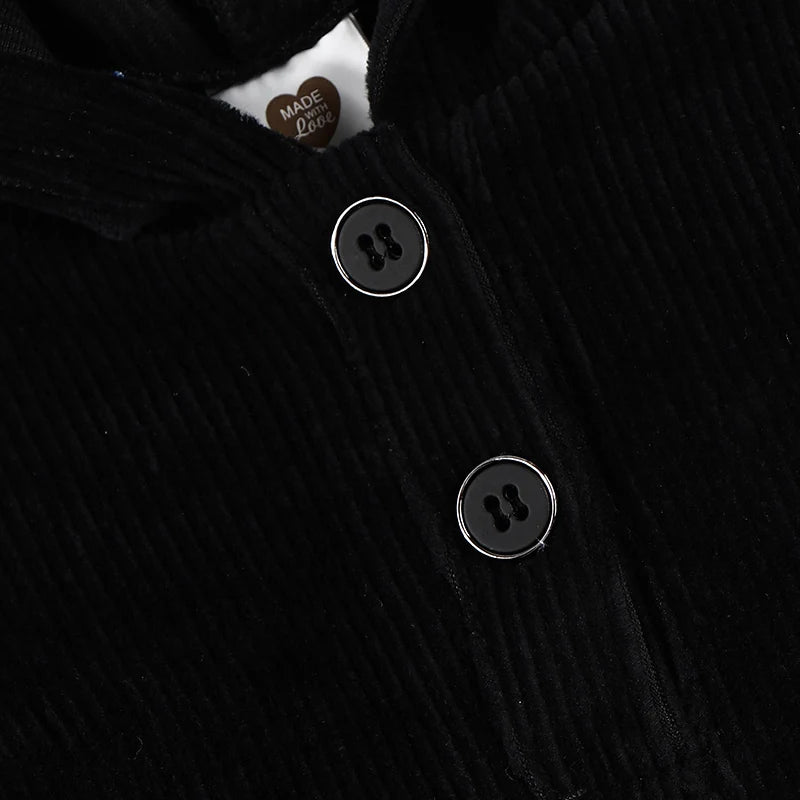Close-up of black corduroy fabric with black buttons on Kids Black Corduroy Hoodie Dress with Denim Side Panel and Kangaroo Pocket