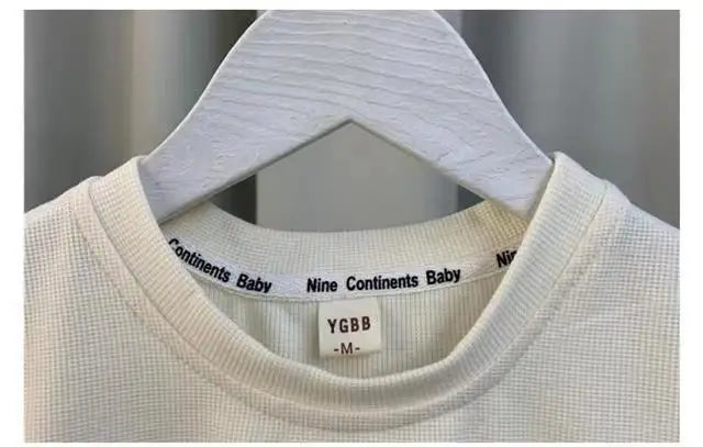 Close-up of white Kids Boys Summer Vest Set New Fashion Baby Net Red Clothes Two Piece Outfits neckline on hanger