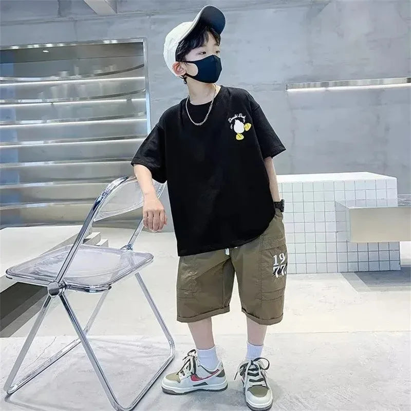 Kids Cartoon Print Cotton T-shirt Streetwear Style Short Sleeve Top Unisex worn by child in black with casual shorts and sneakers