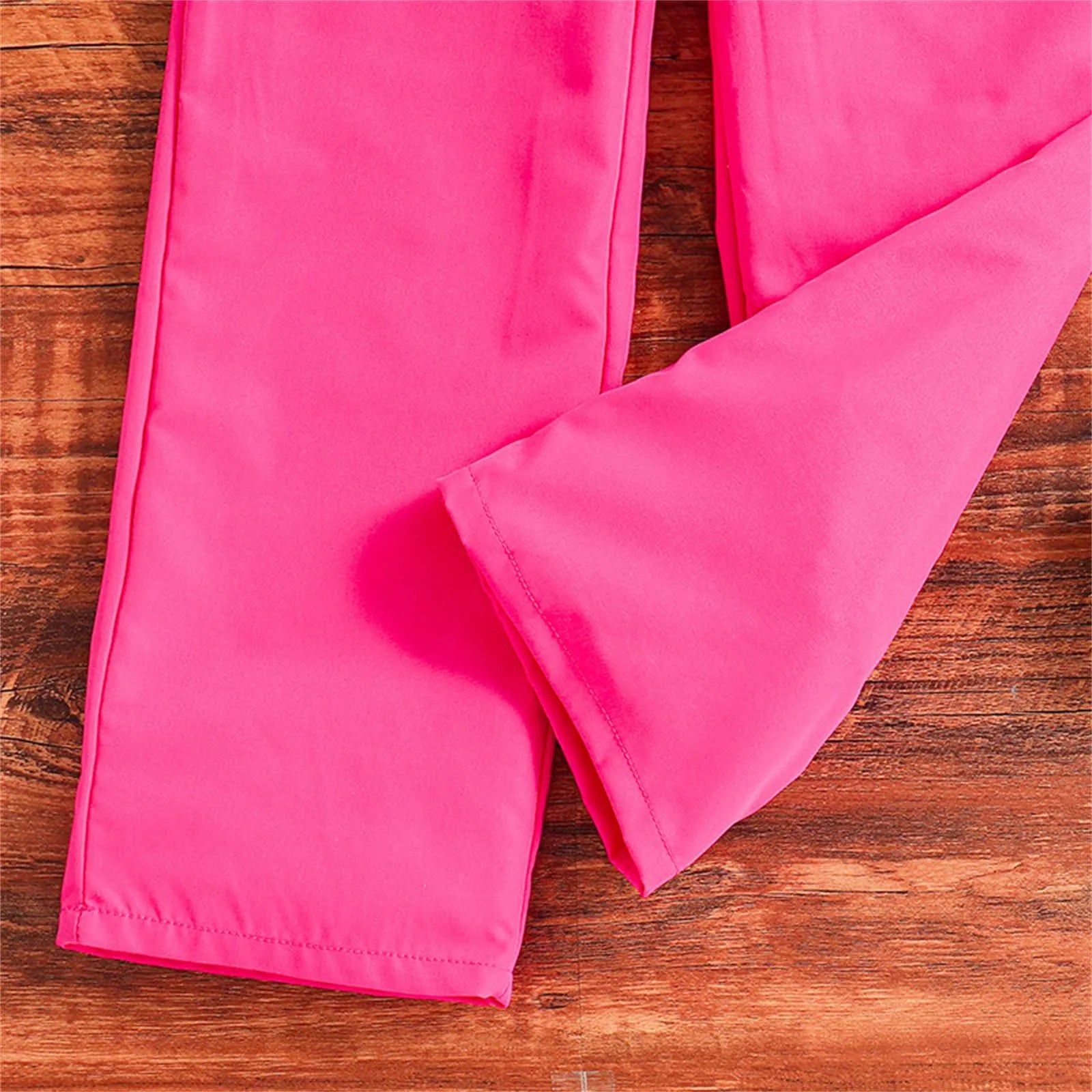 Close-up of pink pants from Kids Casual Clothing Sets Summer Girls Fashion Rose Floral Print White Top Pants on wooden background