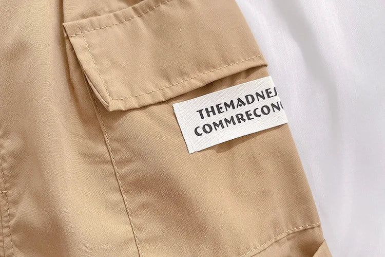 Close-up of beige fabric with pocket and white label from Kids Summer Short-sleeve Polo Shirt Bear & Striped Shorts Baby Boy Set by Yamza Tots' Closet