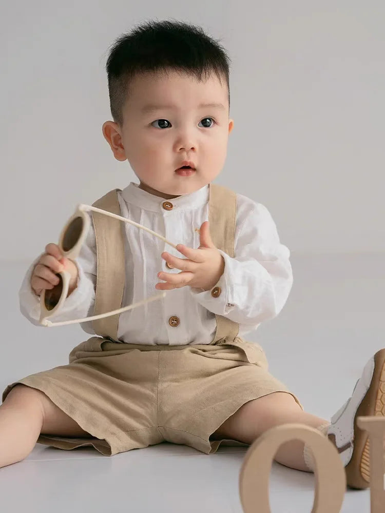 Baby wearing Boy Outfits Cotton Linen T-shirt & Shorts beige set with suspenders sitting on floor