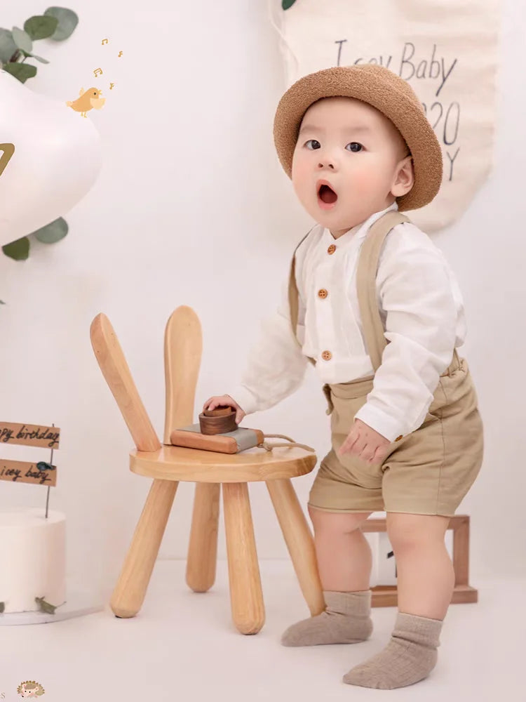 Toddler boy wearing Boy Outfits Cotton Linen T-shirt & Shorts playing near wooden chair with bunny ears