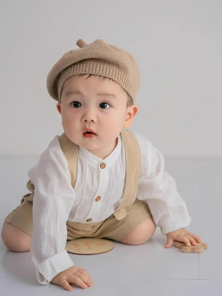 Cute baby wearing Boy Outfits Cotton Linen T-shirt & Shorts with beige hat sitting on floor