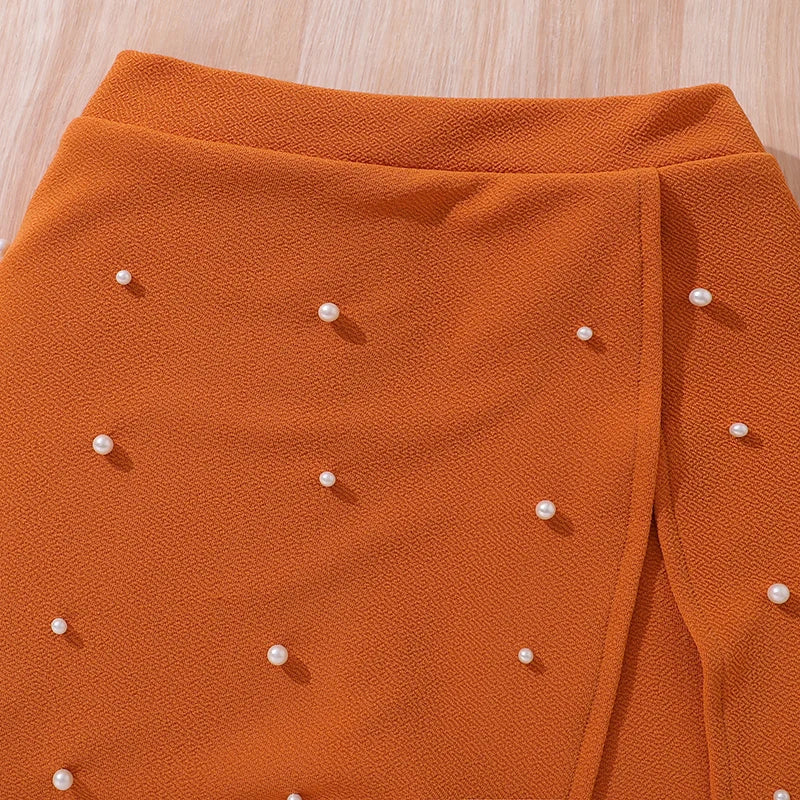 Close-up of orange kids skirt with pearl embellishments from Yamza Tots' Closet