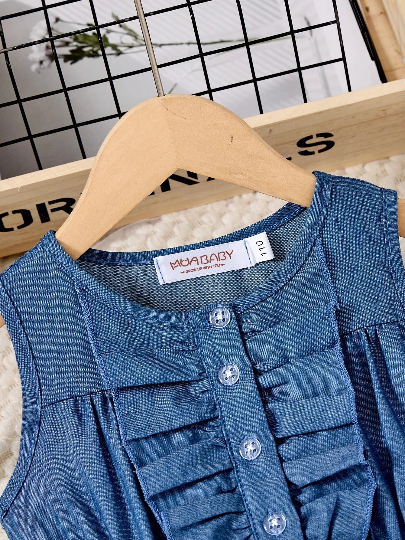 Fashion Girls Dress Summer Casual Patchwork Cowboy Butterfly Floral Design close-up of blue denim sleeveless dress with buttons on wooden hanger